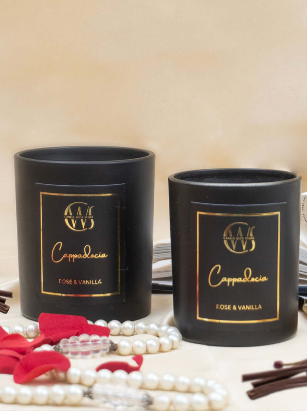 Cappadocia scented candles in black jars with gold labels, featuring rose and vanilla fragrance, styled with accessories.