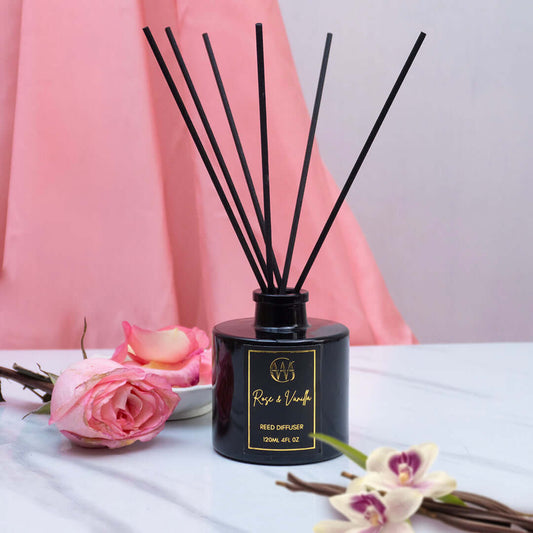 Rose & Vanilla reed diffuser with black reeds, pink roses, and a soft background, perfect for scenting cozy spaces.